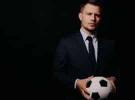 sports executive holding a soccer ball