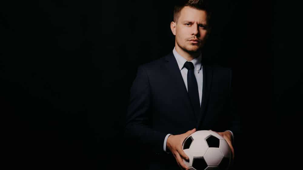 sports executive holding a soccer ball