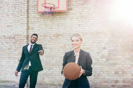 Man and woman sports executives on basketball court.