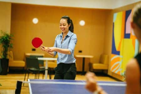 woman playing ping pong in the office.