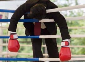 businessman defeated in a boxing ring.