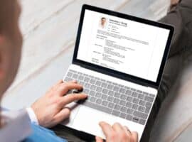 man writing his resume on his computer.