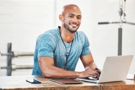 coach smiling while looking away from his computer