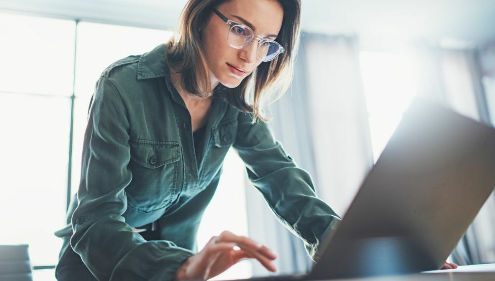 A sports marketing manager working on a laptop