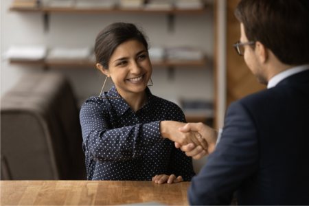 Smiling person shaking hands with the hiring manager after getting an Olympics job