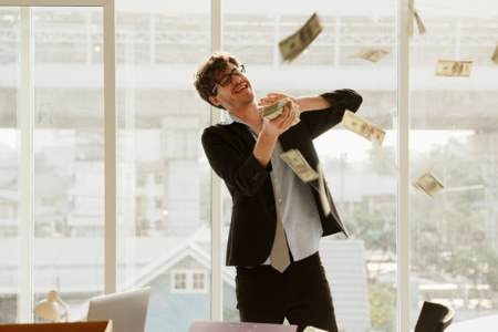 Successful man throwing money in the air