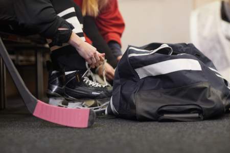 Person learning how to become a hockey referee sitting next to their gear