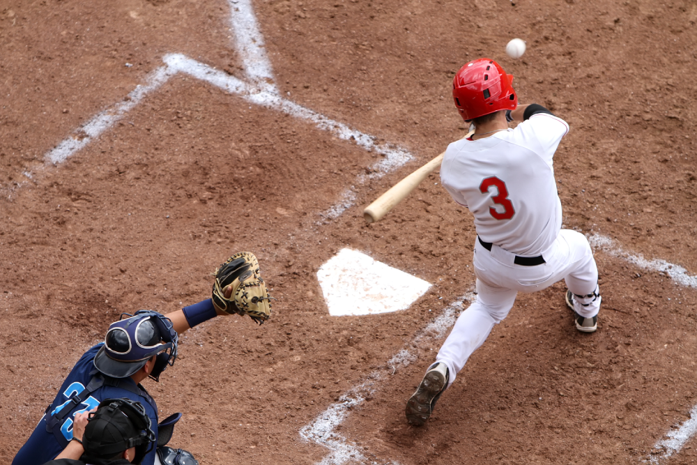 A batter swings at a pitch during a game of baseball.