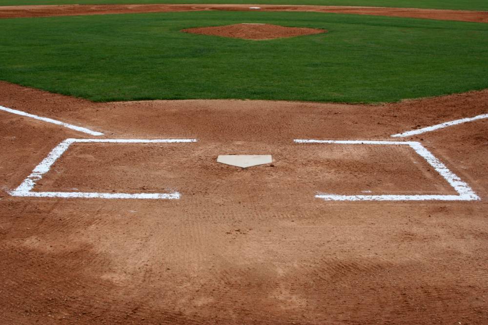 The view of a baseball field from behind home plate.