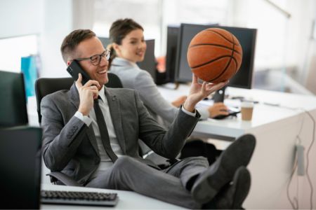 Businessperson in a suit holding a basketball