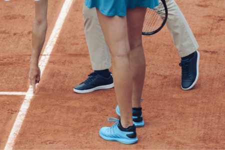 A tennis umpire pointing to where the ball bounced outside of the lines