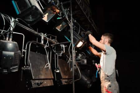 An event technician setting up lights for the Super Bowl