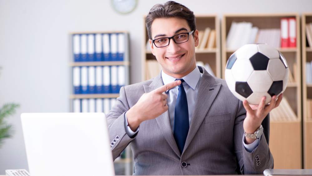 Person with an entry-level sports management job smiling in an office