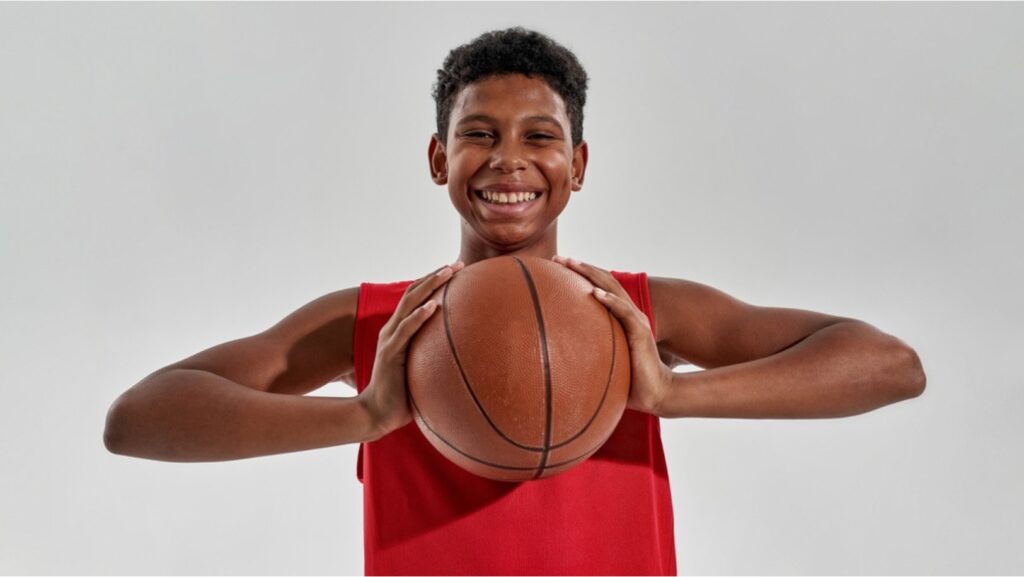  A smiling NBA ball boy holding a basketball