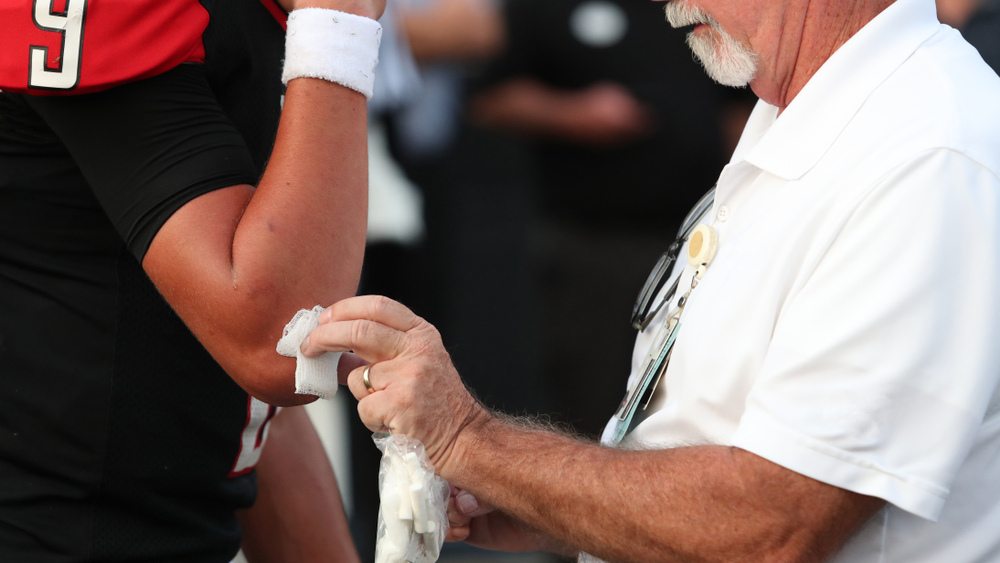 An NFL athletic trainer treating an elbow injury