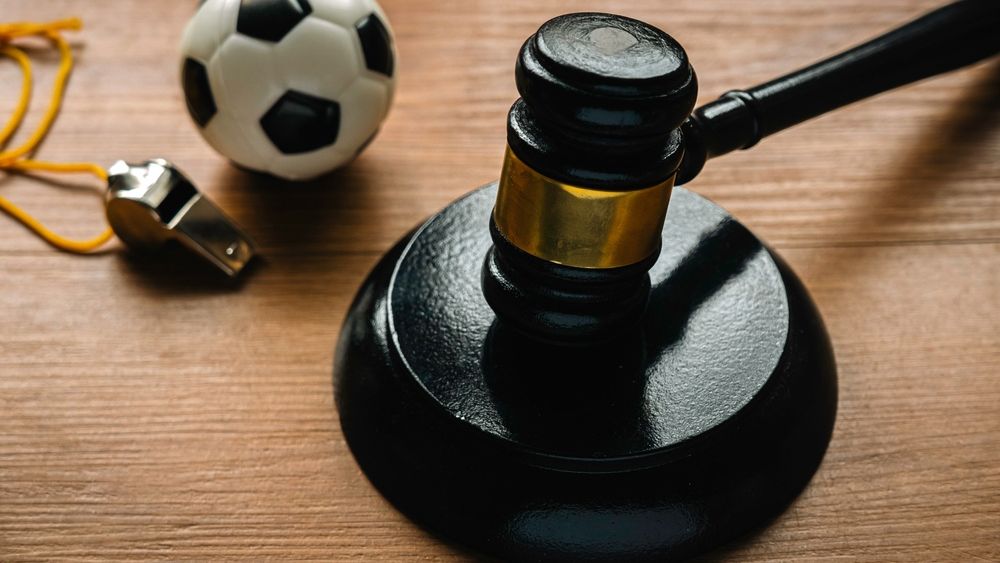 A gavel and a soccer ball on a desk