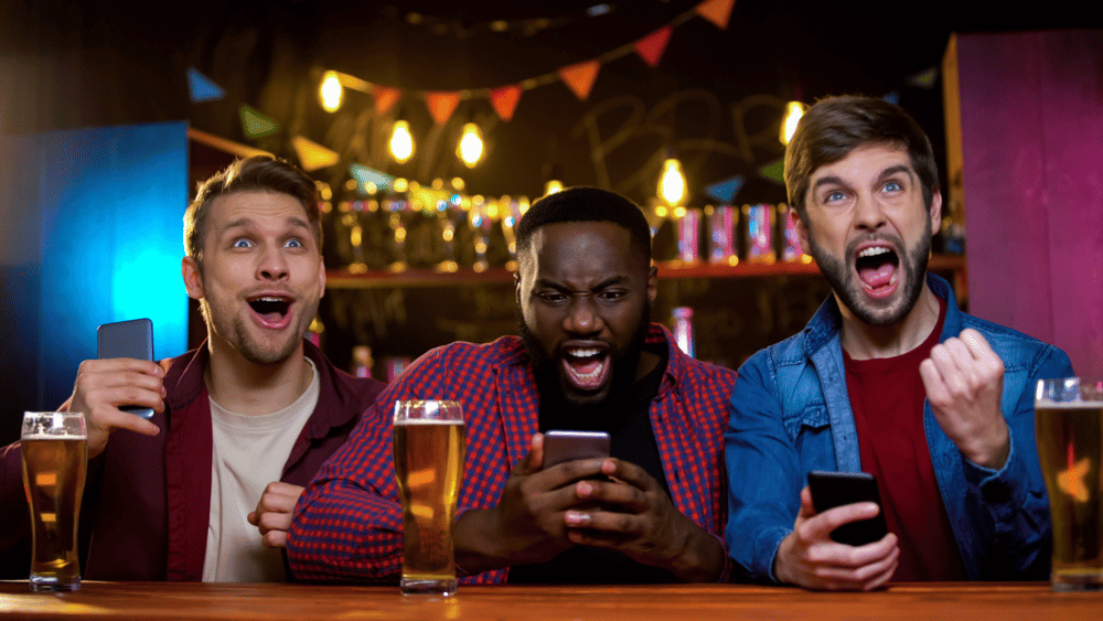 People excited in a bar after making money sports betting