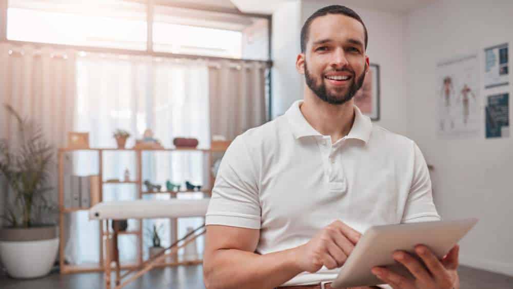 Sports scientist holding a tablet and smiling at the camera