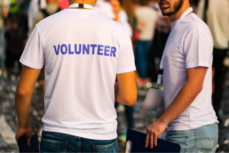 Two people with shirts that say "volunteer"