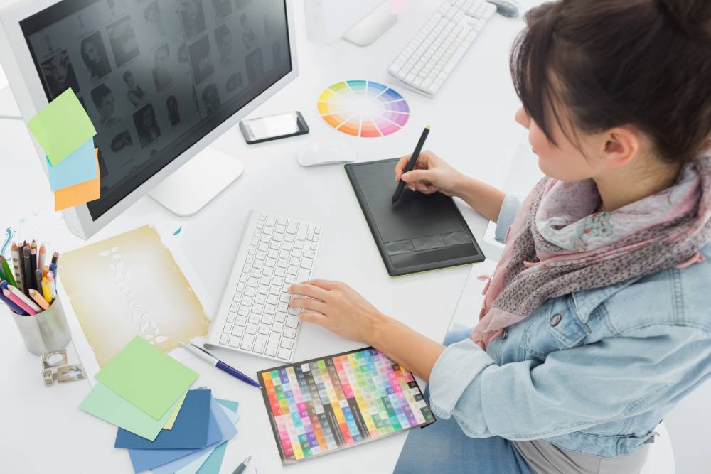  A graphic design intern works on designs for a project.