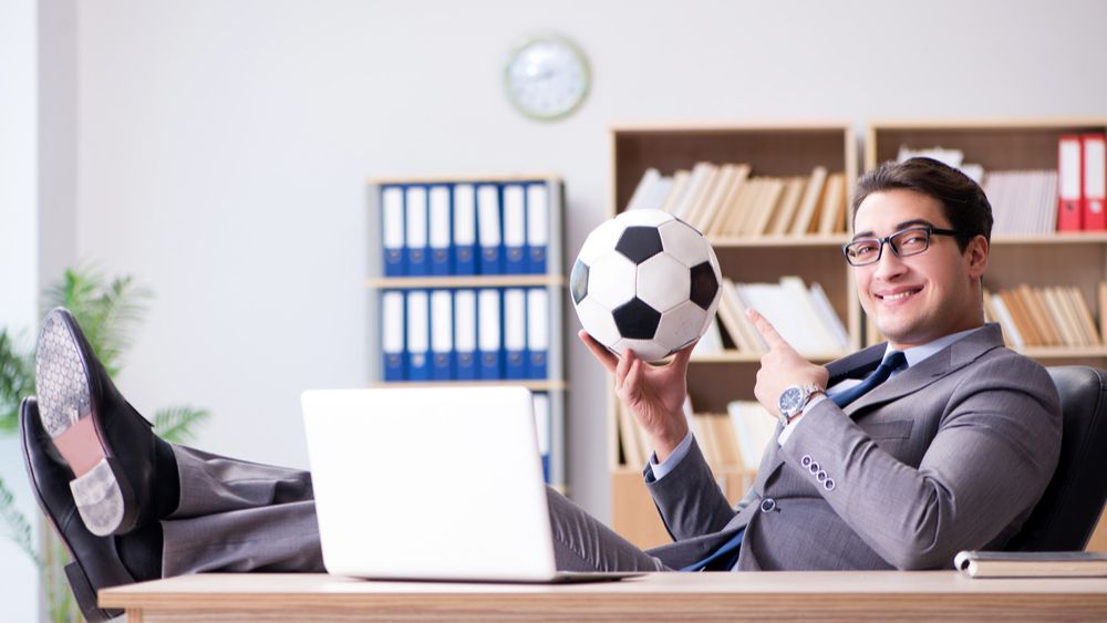 Man with feet up on desk with soccer ball