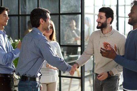 Group of athletic trainers in professional clothes shaking hands