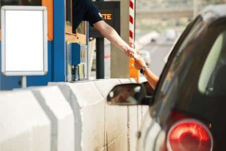 A parking lot attendant accepting cash from someone in a car