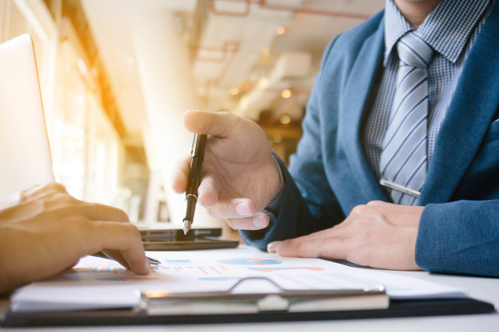 A baseball sales executive goes over figures with a prospective client.