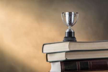 Stack of books with trophy on top of them