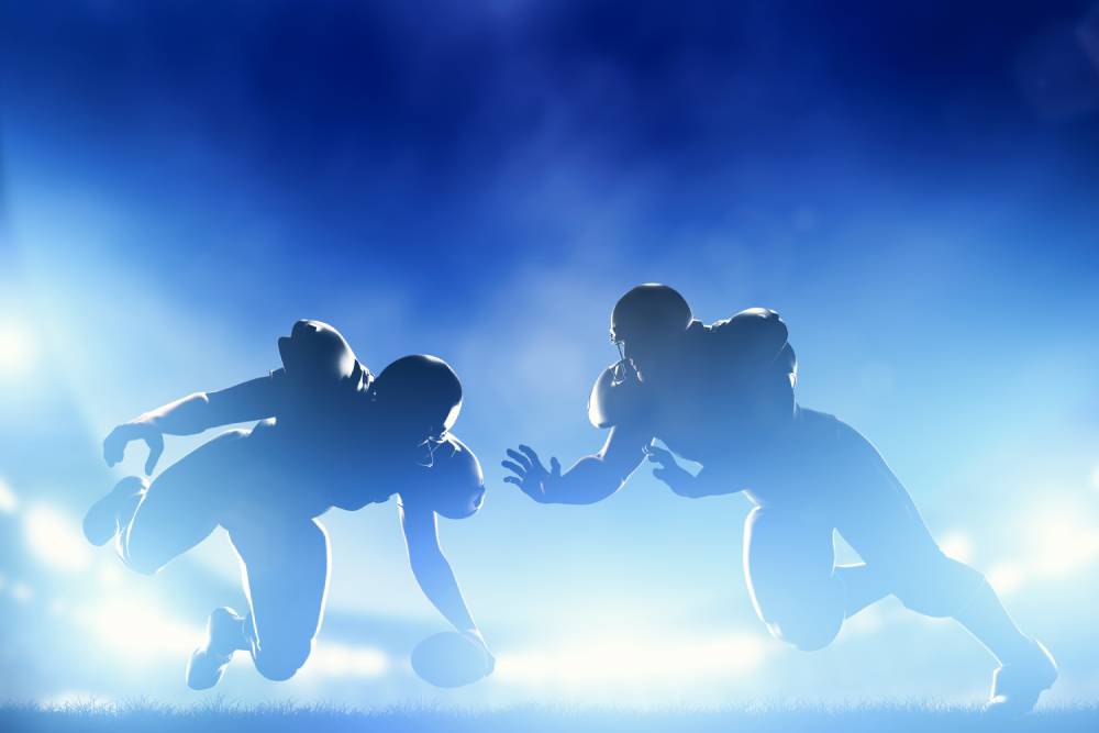 Silhouettes of two football players go head to head in the Super Bowl.