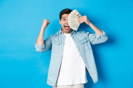 A happy tennis umpire holding hundred dollar bills