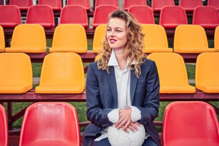 A smiling soccer scout smiling and sitting in the stands