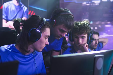 An esports coach discussing a strategy with players on an esports team.