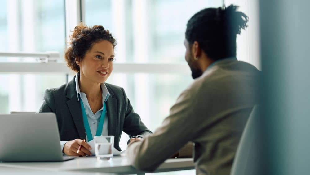 Woman interviewing a man for sports marketing job.