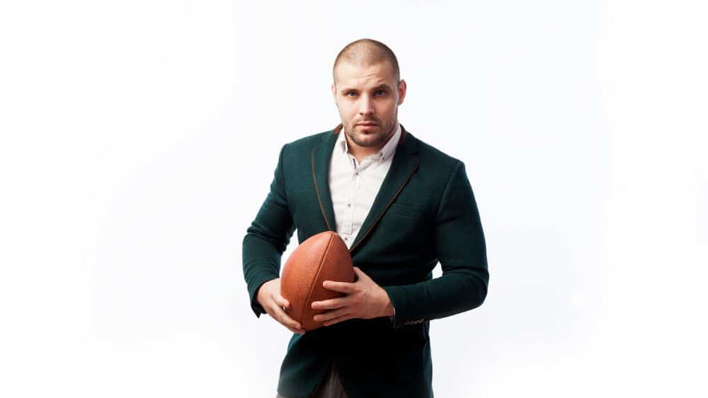 Professional man with NFL sports management jobs experience holding football