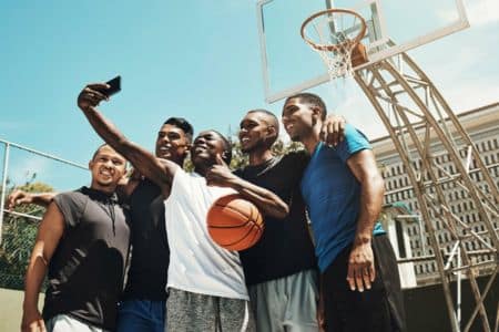 basketball players taking a selfie on the court.