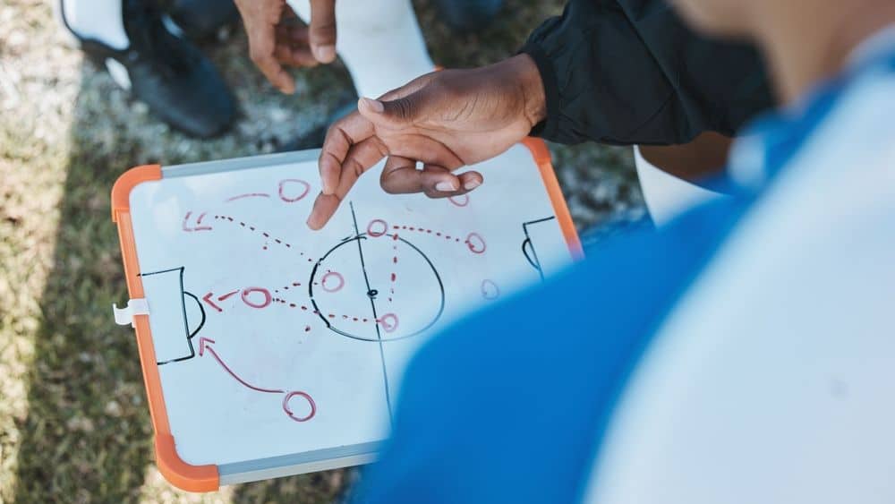 sports manager giving instructions using a whiteboard.