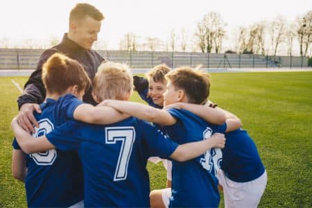 youth coach celebrating with his players.