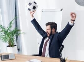 businessman in an office celebrating with a soccer ball.