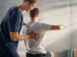 A nurse assisting an athlete with their back.