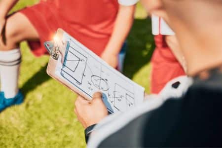 assistant coach giving explanations of tactics to players