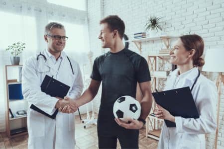 Athlete shaking hands with his medical team.