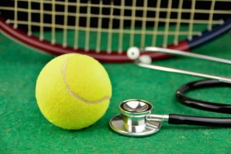 closeup of a tennis ball, a racket, and a stethoscope.