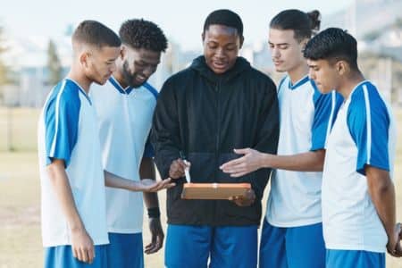 Coach giving instructions to his players.