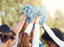 cheer coach and cheerleaders during a motivational huddle.