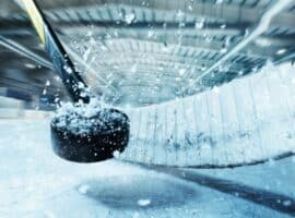 hockey stick hitting hockey puck