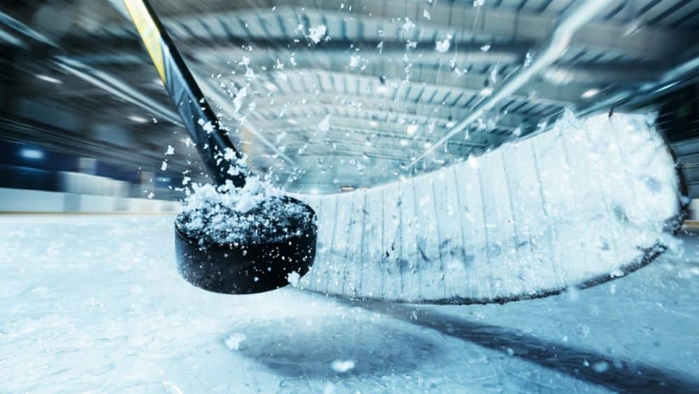 hockey stick hitting hockey puck