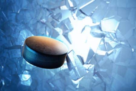  hockey puck breaking through glass to represent how to get a job with an nhl team
