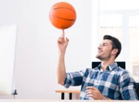 man spinning a basketball at the office desk