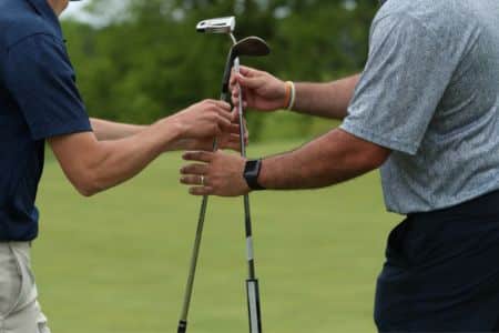 caddie handing an iron club to the player during a round.